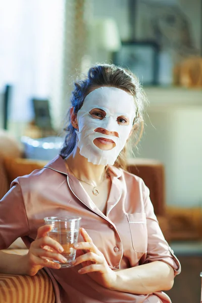 Modern Female Pajamas White Sheet Facial Mask Face Holding Glass — Stock Photo, Image