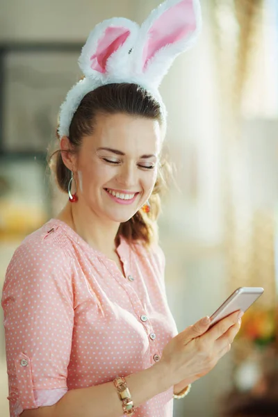 Uśmiechnięta Kobieta Średnim Wieku Różowej Bluzce Wielkanocnych Uszach Króliczka Nowoczesnym — Zdjęcie stockowe