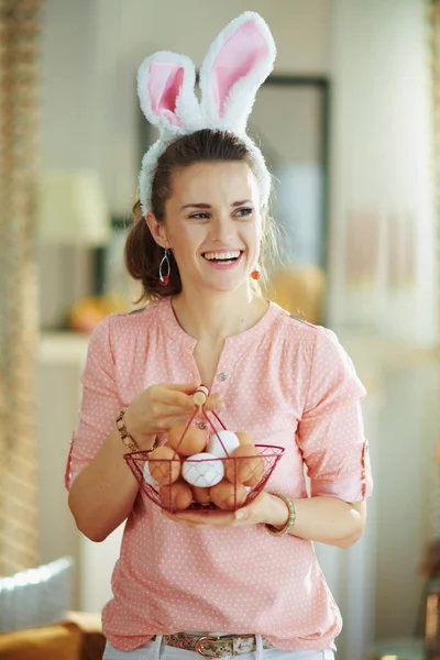 Pembe Bluzlu Mutlu Orta Yaşlı Kadın Renkli Sepetli Paskalya Tavşanı — Stok fotoğraf