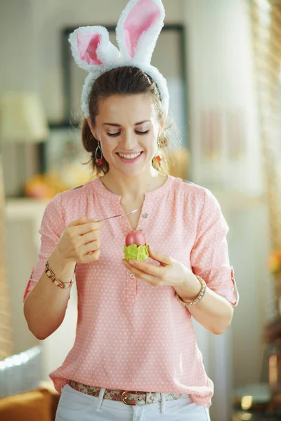 Sorridente Jovem Fêmea Uma Blusa Rosa Orelhas Coelho Páscoa Comendo — Fotografia de Stock
