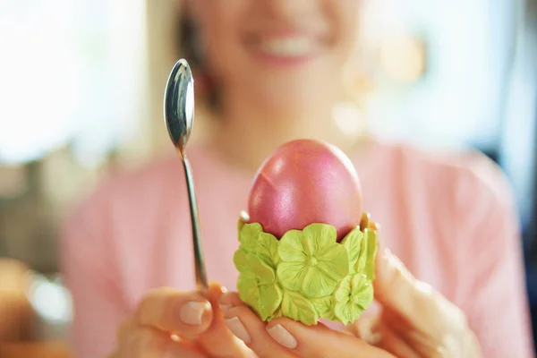 晴れた春の日に自宅で女性の閉鎖は緑色の卵カップでスプーンと赤いイースターの卵を示しています — ストック写真