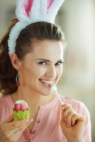 Lykkelig Elegant Kvinde Lyserød Bluse Påskeharer Ører Spise Rødt Påskeæg - Stock-foto