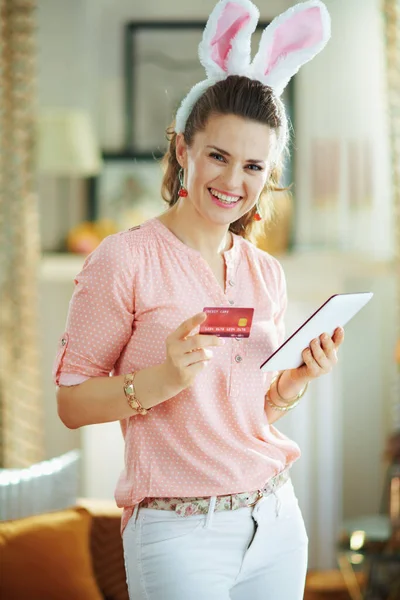 Mosolygós Elegáns Rózsaszín Blúzban Húsvéti Nyuszi Fülek Hitelkártya Segítségével Tabletta — Stock Fotó