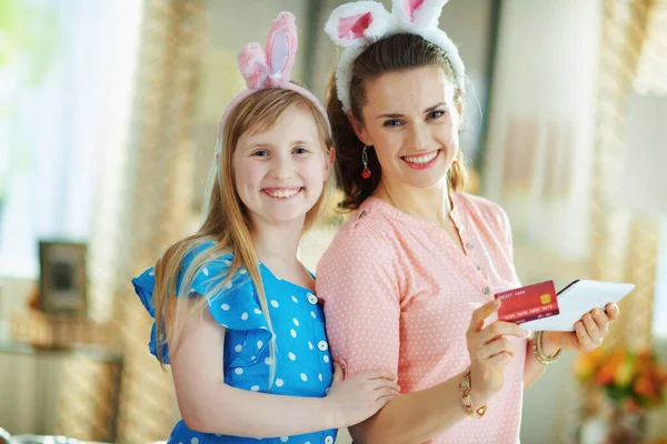 阳光明媚的春日 快乐的年轻母亲和女儿带着信用卡在平板电脑上在线购物 — 图库照片