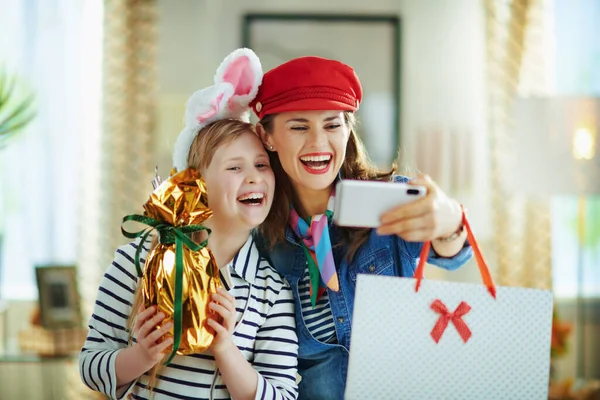 Sonriendo Elegante Madre Hija Con Envuelto Papel Oro Huevo Pascua — Foto de Stock
