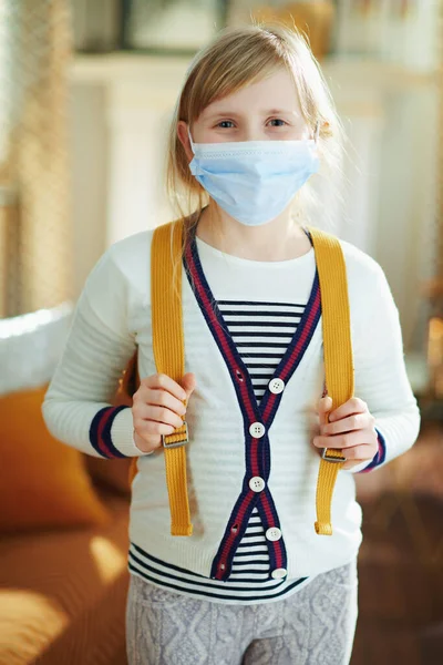 Fiatal Gyermek Fehér Csíkos Pólóban Orvosi Maszkkal Hátizsákkal Modern Otthon — Stock Fotó