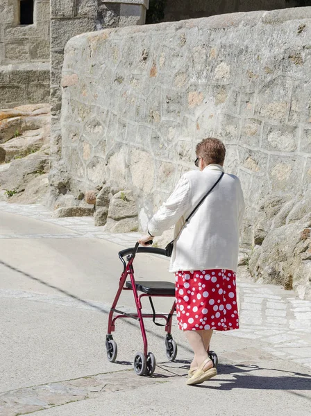 Old lady walking with a walking frame