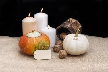 İki organik ve sağlıklı balkabağı, üç mum, biraz ceviz ve fotokopi alanı olan bir kutu. Cadılar Bayramı konsepti.