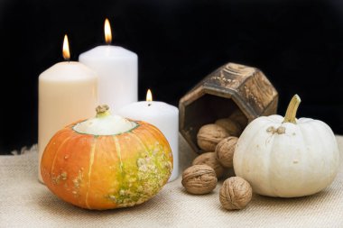 İki organik ve sağlıklı balkabağı, üç mum, biraz ceviz ve fotokopi alanı olan bir kutu. Cadılar Bayramı konsepti.