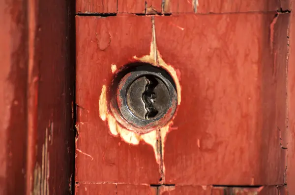 Keyhole lock on red wooden door — Stock Photo, Image