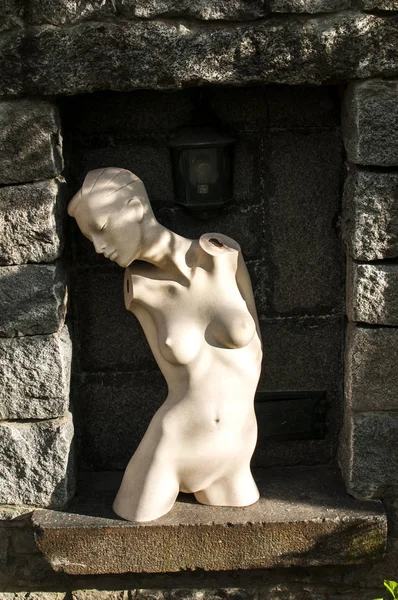Торс женского манекена в нише каменного забора — стоковое фото