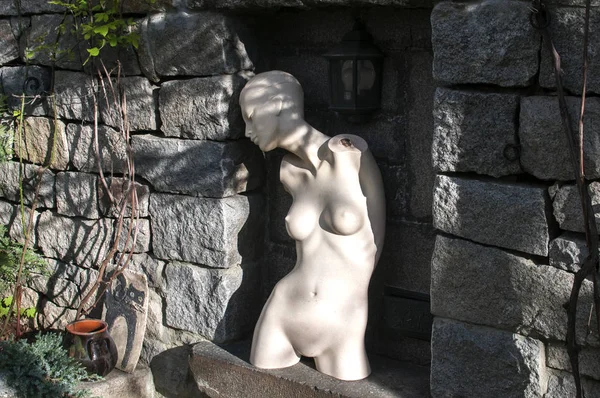 Торс женского манекена в нише каменного забора — стоковое фото