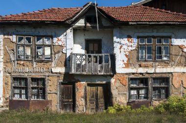 Çürümüş grunge kırsal çürük evi kil ufalanmış Cephesi ihmal edilen ahşap pencere, balkon ve kapı ile terk edilmiş
