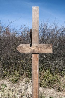 Ahşap işareti açık güneşli bir günde kırsal artalan üzerinde farklı yönlere iki boş ok ile göndermek