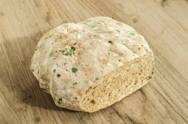 Ahşap arka plan üzerinde küflü ve küflü yuvarlak kepekli ekmek