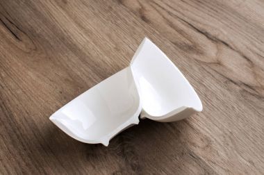 İki yarıyı da küçük beyaz porselen kase closeup ahşap tahta arka plan üzerinde kırık