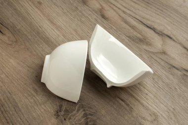 İki yarıyı da küçük beyaz porselen kase closeup ahşap tahta arka plan üzerinde kırık