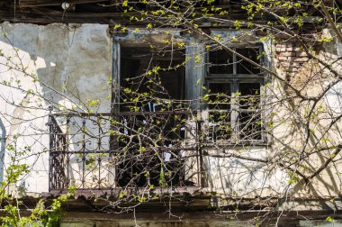 Terk edilmiş eski köy evinin balkonuyla yüz yüze.