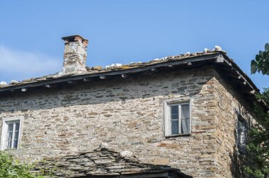 Kırsal kesimdeki taştan bir ev, güneşli bir yaz gününde.