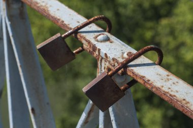 Kilitli asma kilitler güneşli bir günde demir parmaklıklara kapanır.
