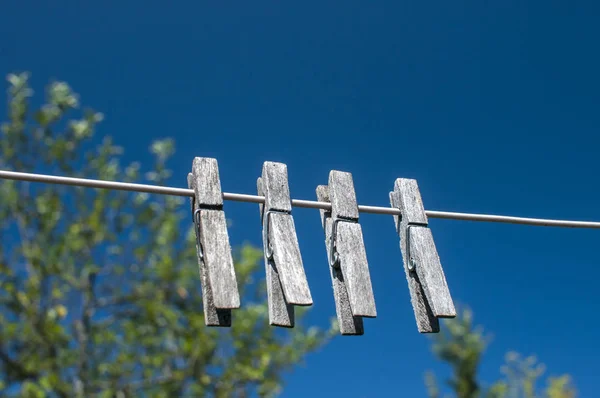 Väderbitna Trä Tvättklämmor Hängande Ett Snöre Blå Himmel Bakgrund — Stockfoto