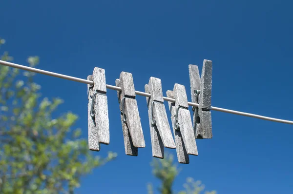 Pinzas Lavandería Madera Envejecida Que Cuelgan Una Cuerda Fondo Azul —  Fotos de Stock