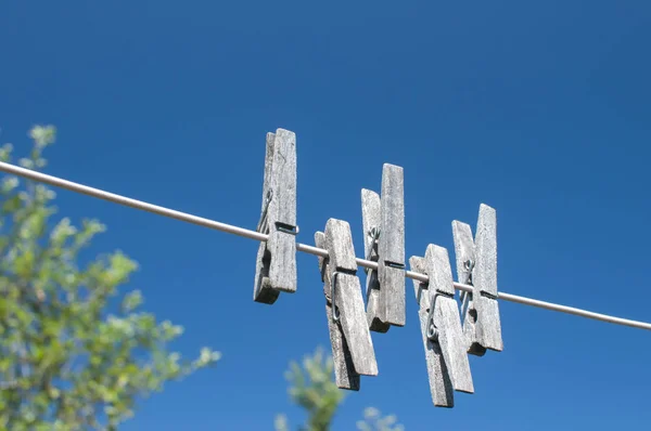 Pinzas Lavandería Madera Envejecida Que Cuelgan Una Cuerda Fondo Azul —  Fotos de Stock