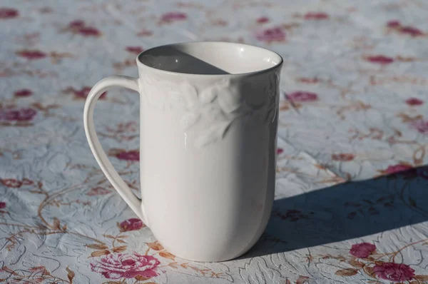 屋根付きのテーブルの上に白い磁器ミルクマグカップのクローズアップ — ストック写真