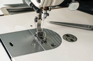 Dikiş makinesinin iğnesi ve ayağı imalat arka planı olarak kapatılıyor