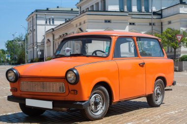 Asfaltlı caddede turuncu renkli eski Trabant arabası restore edildi
