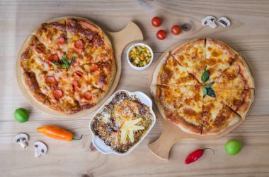 İtalyan pizzası ve makarnası ahşap masada servis edilir..