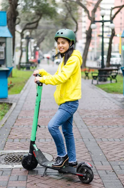 Elektrikli scooterlı genç bir kadın.