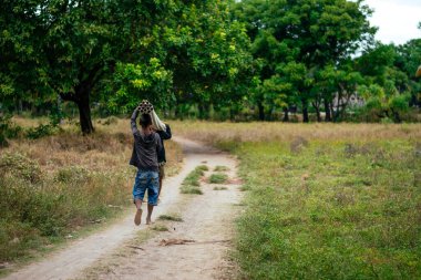 Endonezya 'da omuzlarında plastik borular taşıyan iki işçi..