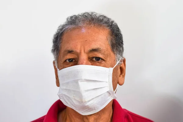 Senior Peruvian man suffers from cough with face mask protection, elderly man with facial mask due to air pollution, sick elderly with medical mask, pollution