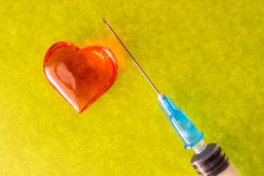 pütürlü yüzeyi bir şırınga ve kalp, aşk fotoğrafını kağıt renkli