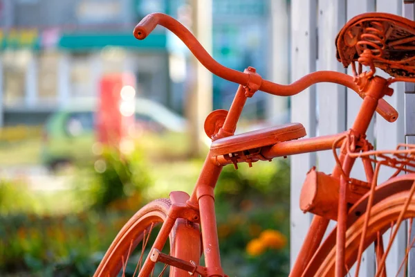 orange bike near the wall on the background of summer the city