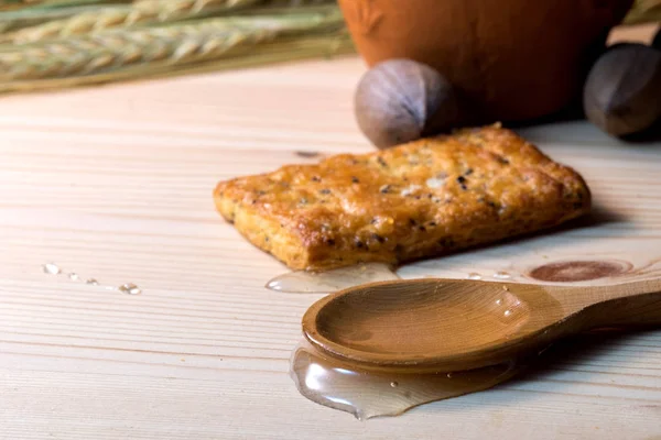 Untar la miel en una mesa de madera debajo de una cuchara de madera — Foto de Stock