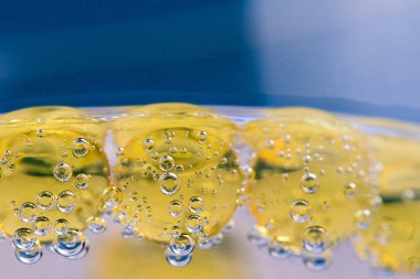 Morina karaciğer yağı omega 3 kapsülleri mavi zemin üzerine. Su altında