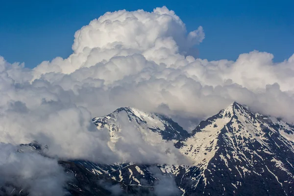 Large white clouds stuck on mountain tops — Stock Photo, Image