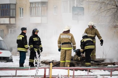 Kamensk-Uralsky, Rusya Federasyonu, 10 Şubat 2018: İtfaiye yangın bir çok katlı bina arka plan üzerinde kaynak ortadan kaldırmak
