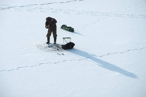 Pêche d'hiver pêcheur perce un trou pour la pêche, la glace et l'hiver — Photo