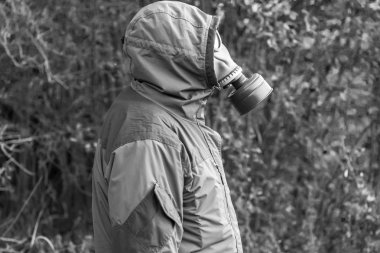 bir adam ayakta bir gaz maskesi, siyah beyaz fotoğraf