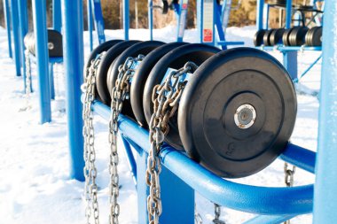 Açık mavi dumbbells bir zinciri ücretsiz bir spor salonu isteyen herkes için açık bir yerde spor yapıyor, bağlı