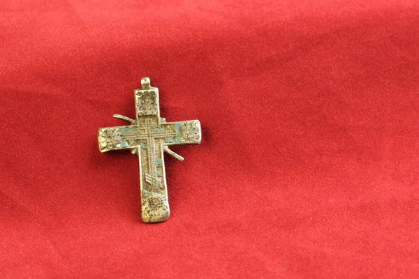 На красной ткани является древним религиозным символом креста русский старый XVIII век из меди — стоковое фото