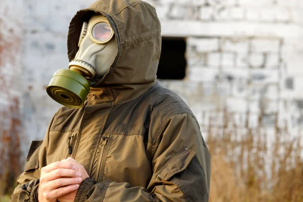 Esperança o resultado na máscara de gás a pessoa no edifício arruinado de fundo, outono na Rússia — Fotografia de Stock