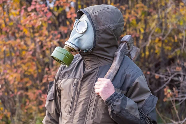 Topór na ramieniu człowieka w masce gazowej, Rosja jesienią — Zdjęcie stockowe