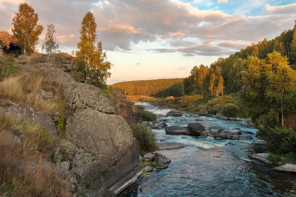 travel to Russia fast mountain river with stone banks in the sky clouds