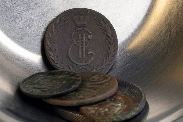 Monedas antiguas apiladas en un recipiente de metal de color plateado, luz y sombra de metal — Foto de Stock