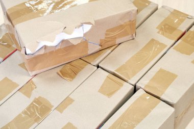 Diğer paketlerin arka planında kağıt kapaklı hasarlı paketleme