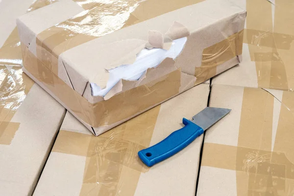 Pacote rasgado e faca na abertura do armazém e triagem no centro de logística — Fotografia de Stock